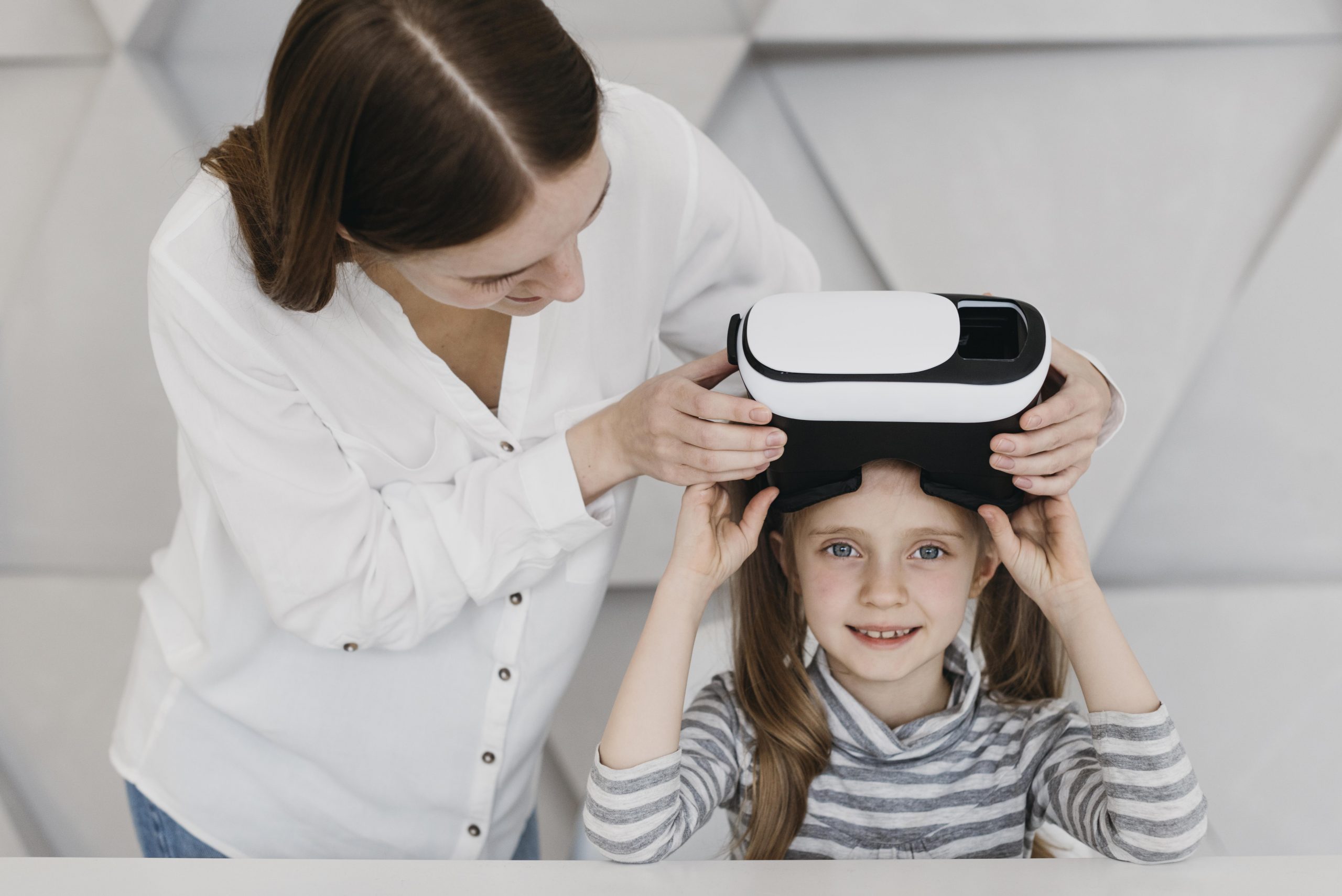 Una maestra ayuda a su alumna con las gafas de Realidad Virtual
