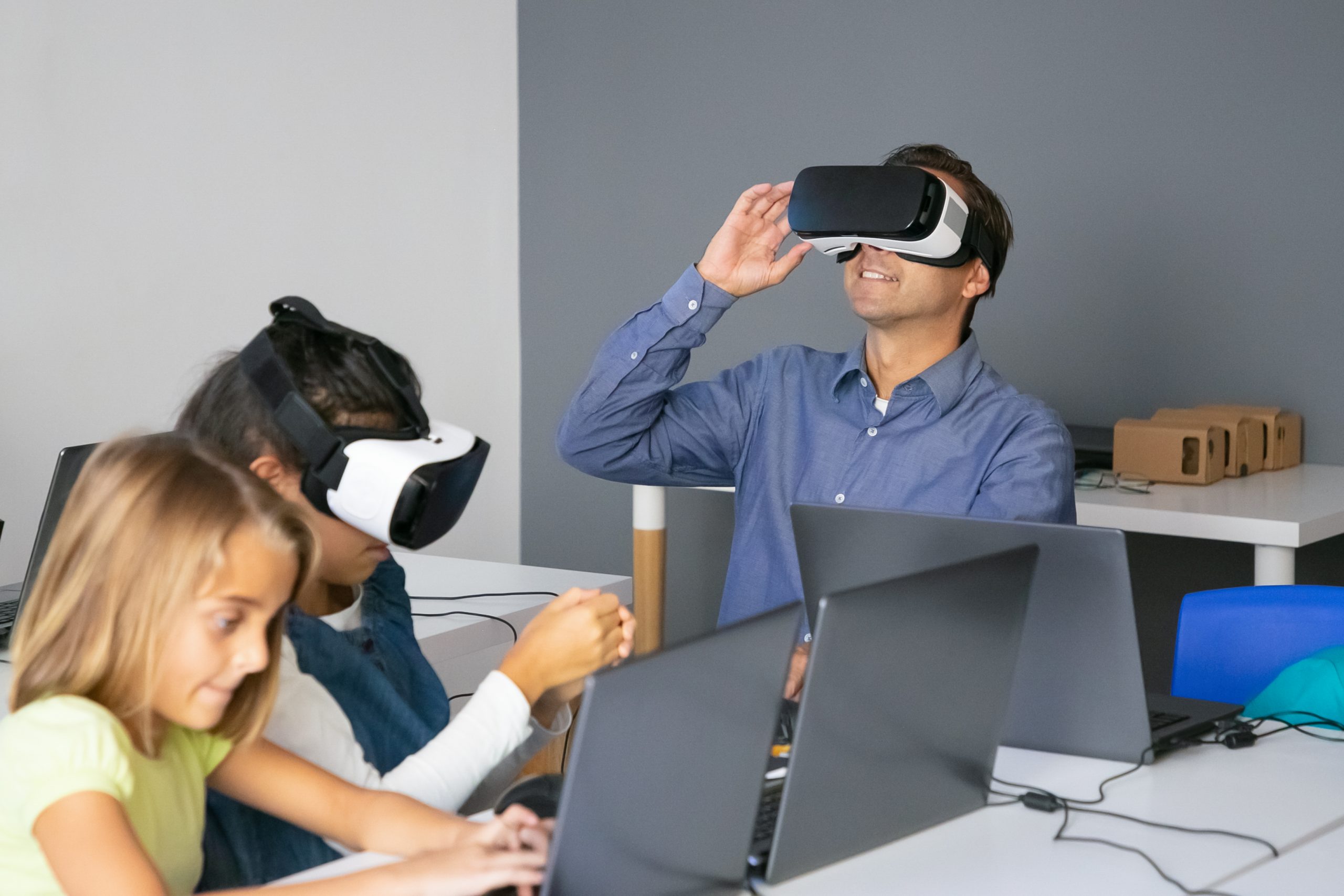 Un profesor y dos alumnas usan gafas de realidad virtual